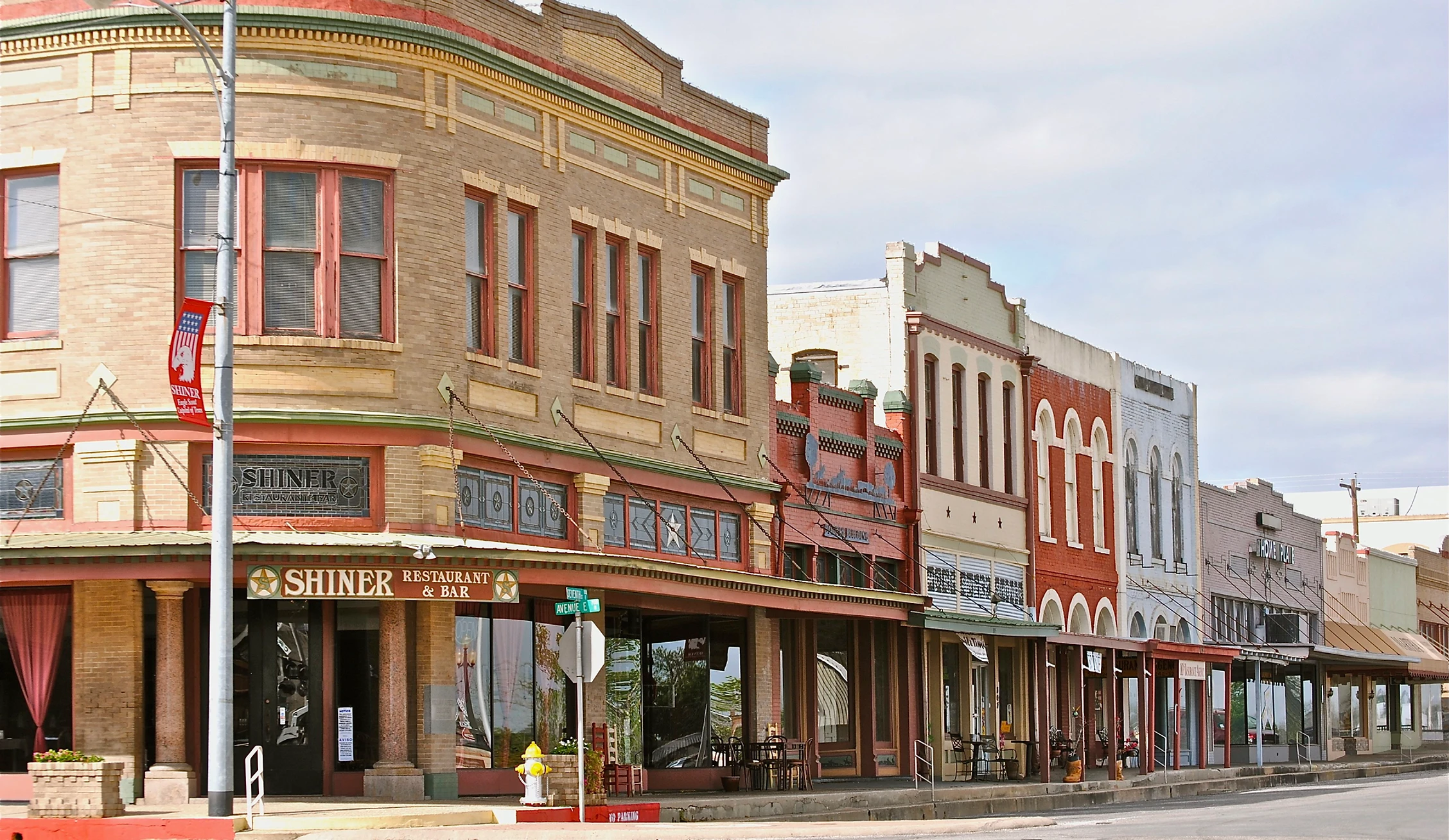 Street view of a historic downtown block in Shiner, featuring a row of old-fashioned buildings with distinctive architecture.